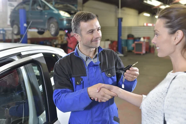 Meccanico dando le chiavi dell'automobile al cliente — Foto Stock