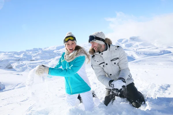 Coppia facendo palle di neve lotta — Foto Stock