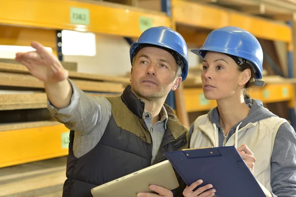 Arbetare med övervakare kontrollerar lager — Stockfoto