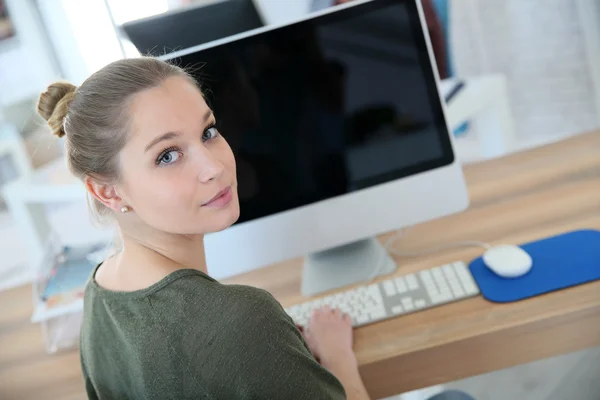 Flickan sitter framför skrivbordet — Stockfoto