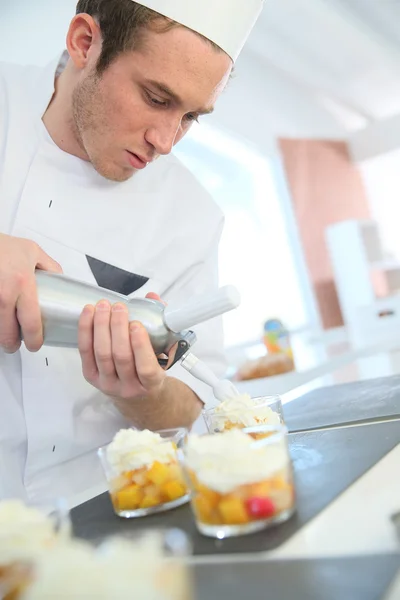 Cocinero pastelero extendiendo crema batida — Foto de Stock