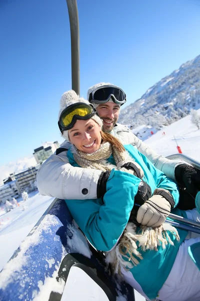 Couple on ski resort chairlift — Stock Photo, Image