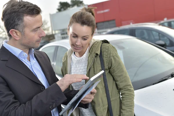 Car dealer showing car specifications — Stock Photo, Image