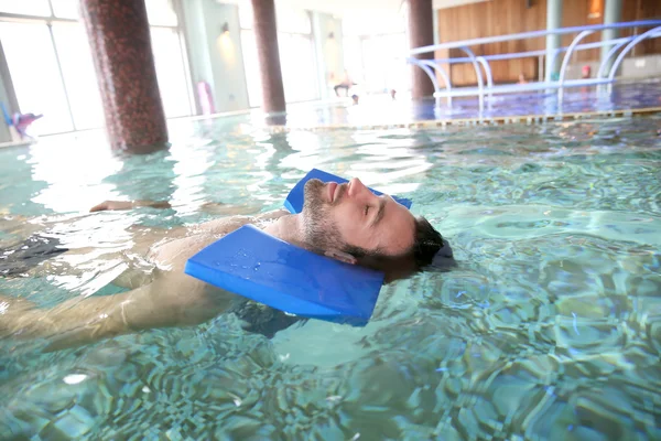 Человек в бассейне делает упражнения — стоковое фото