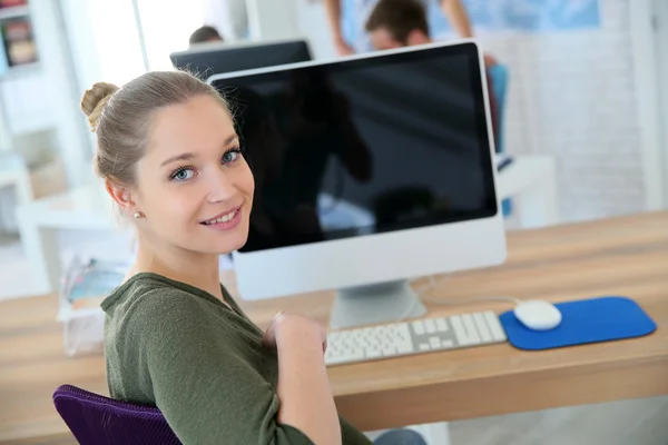 Flickan sitter framför skrivbordet — Stockfoto