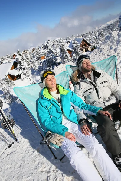 Skifahrer sonnen sich in langen Stühlen — Stockfoto