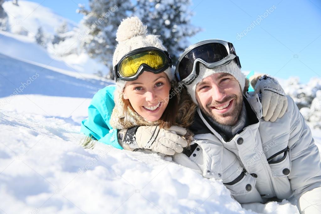 Couple laying down in snow