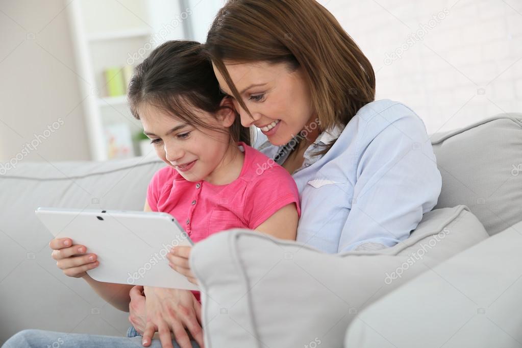 Mother with girl websurfing on tablet