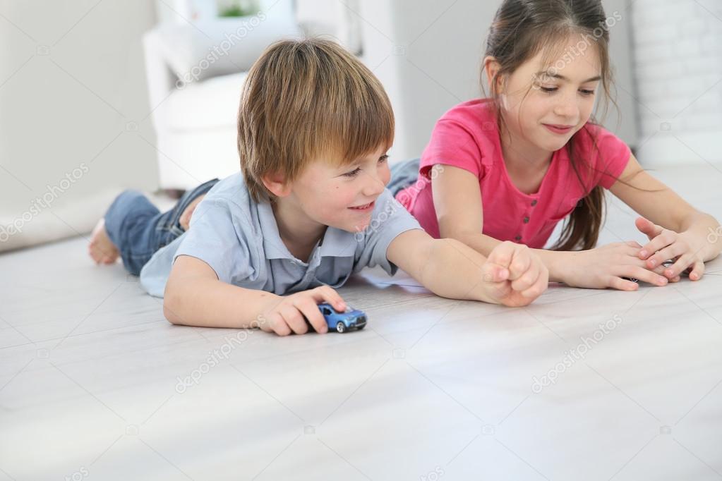 Kids playing with cars on floor