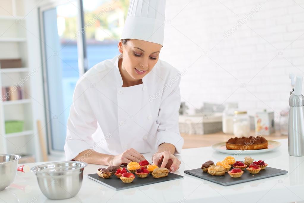 Pastry-cook preparing plate of cake bites