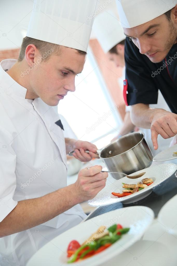 Chef with cook in kitchen