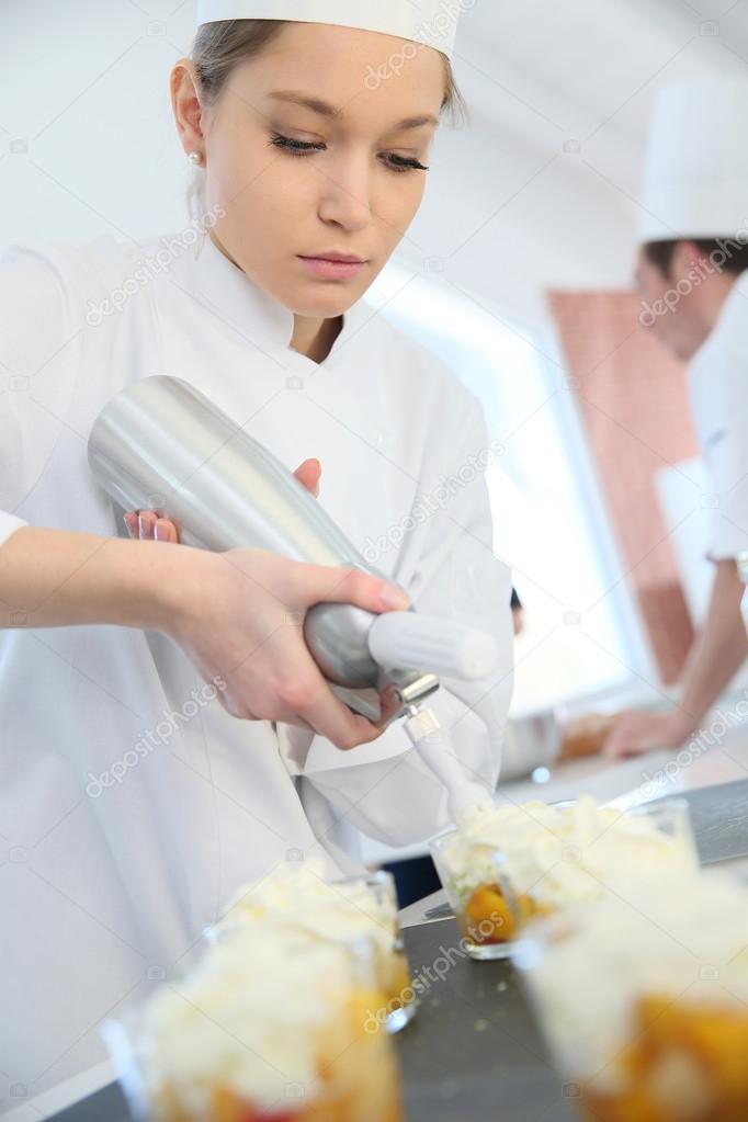 Pastry cook spreading whipped cream