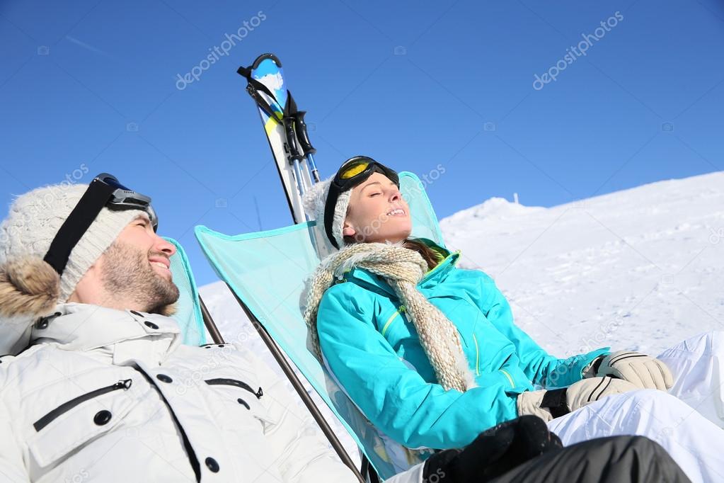 Skiers sunbathing at ski slope