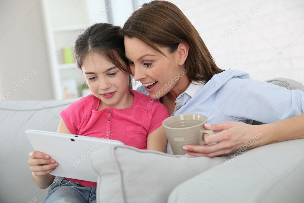 Mother with girl websurfing on tablet