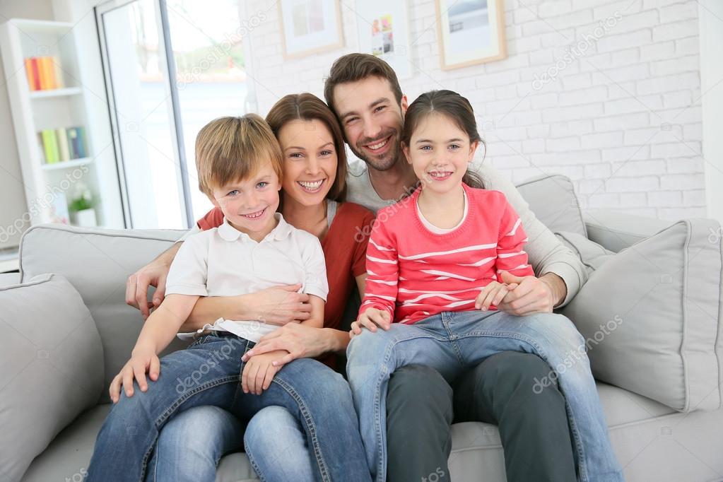 Family sitting on sofa — Stock Photo © Goodluz 67894563