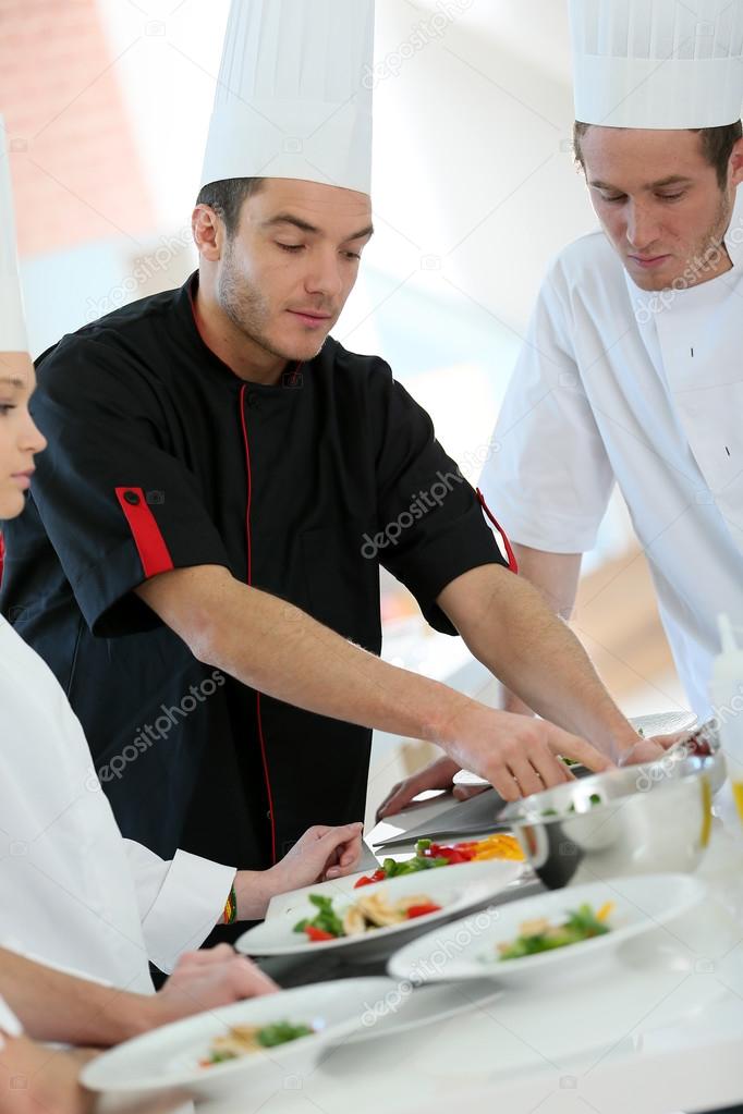 Chef training students in kitchen