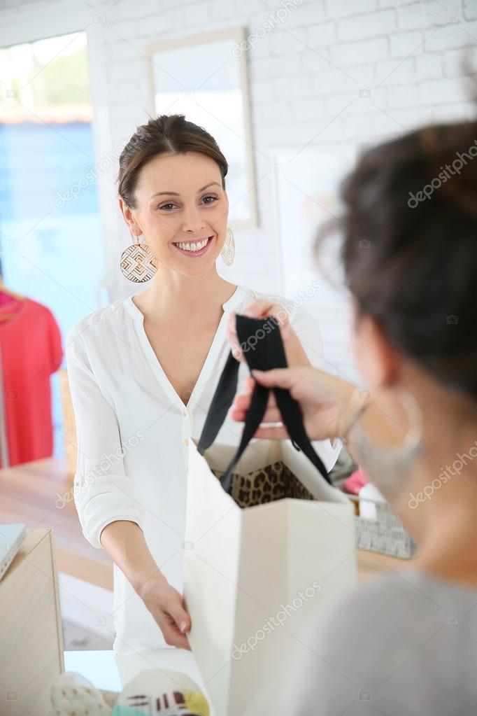 Seller woman giving purchase bag