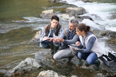 Biologist with students testing river water clipart