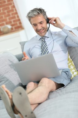 Kanepede kulaklık ile işadamı