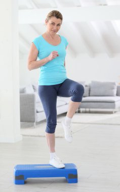 Woman doing step exercises clipart