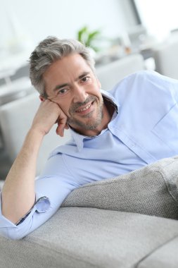 Man relaxing on sofa clipart