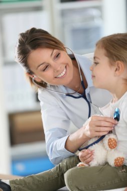 Doctor examining girl with stethoscope clipart