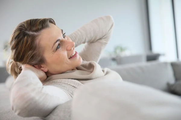 Mujer relajante en sofá — Foto de Stock