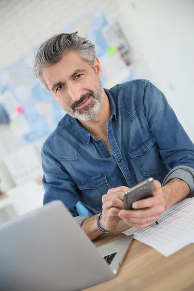 Insegnante utilizzando laptop e smartphone — Foto Stock