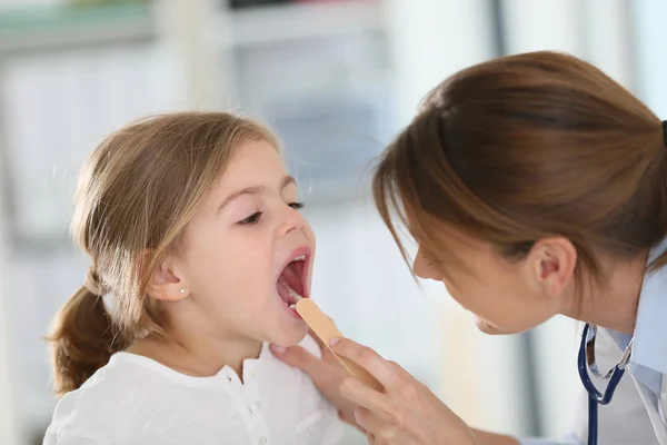 Doctor examining throat and mouth — Stock Photo, Image