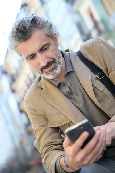 Killen med smartphone på bänk — Stockfoto