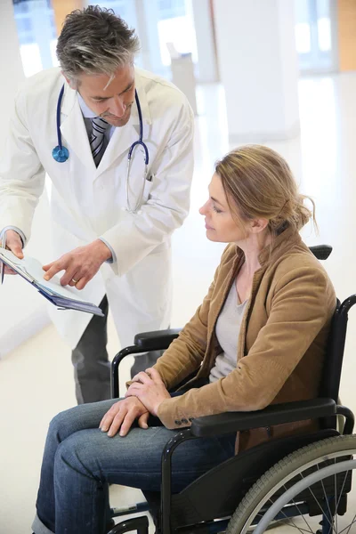 Médico falando com mulher em cadeira de rodas — Fotografia de Stock