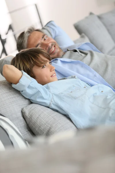 Vader en zoon ontspannen op de sofa — Stockfoto