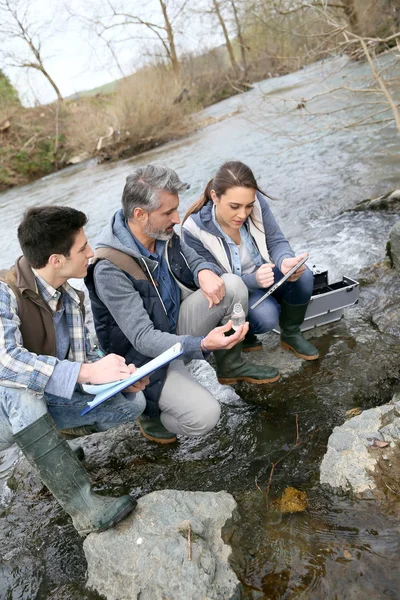 Biólogo con estudiantes analizando el agua del río —  Fotos de Stock