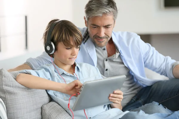 Father watching kid playing with tablet — Stock Photo, Image