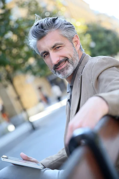 Man websurfing with tablet on bench — Stock Photo, Image