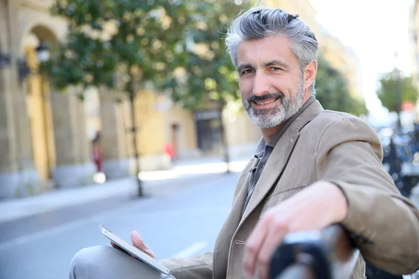 Mann surft mit Tablet auf Bank — Stockfoto