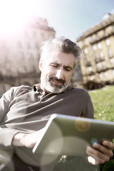 Homem conectado em tablet no parque — Fotografia de Stock