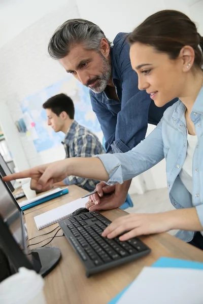 Lärare med människor i datorvärlden klass — Stockfoto