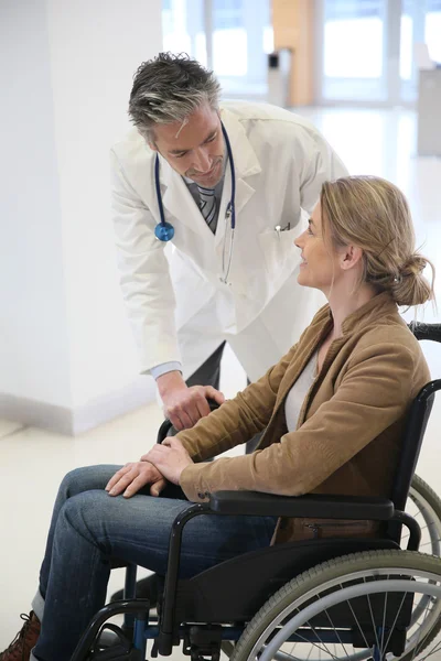 Doctor talking to woman in wheelchair — Stock Photo, Image