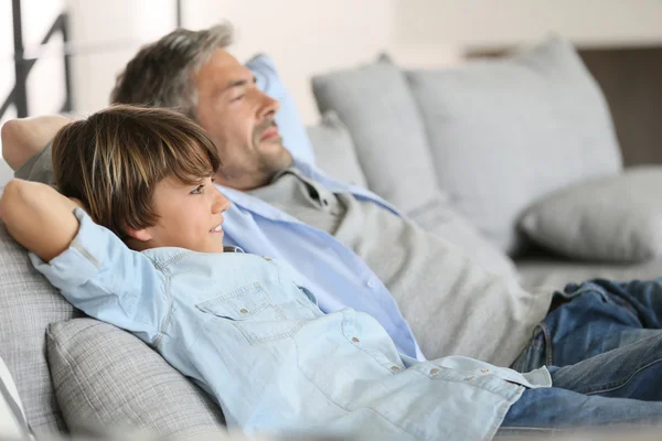 父亲和儿子躺在沙发上， — 图库照片