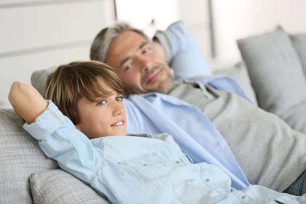 Father and son relaxing on sofa — Stock Photo, Image