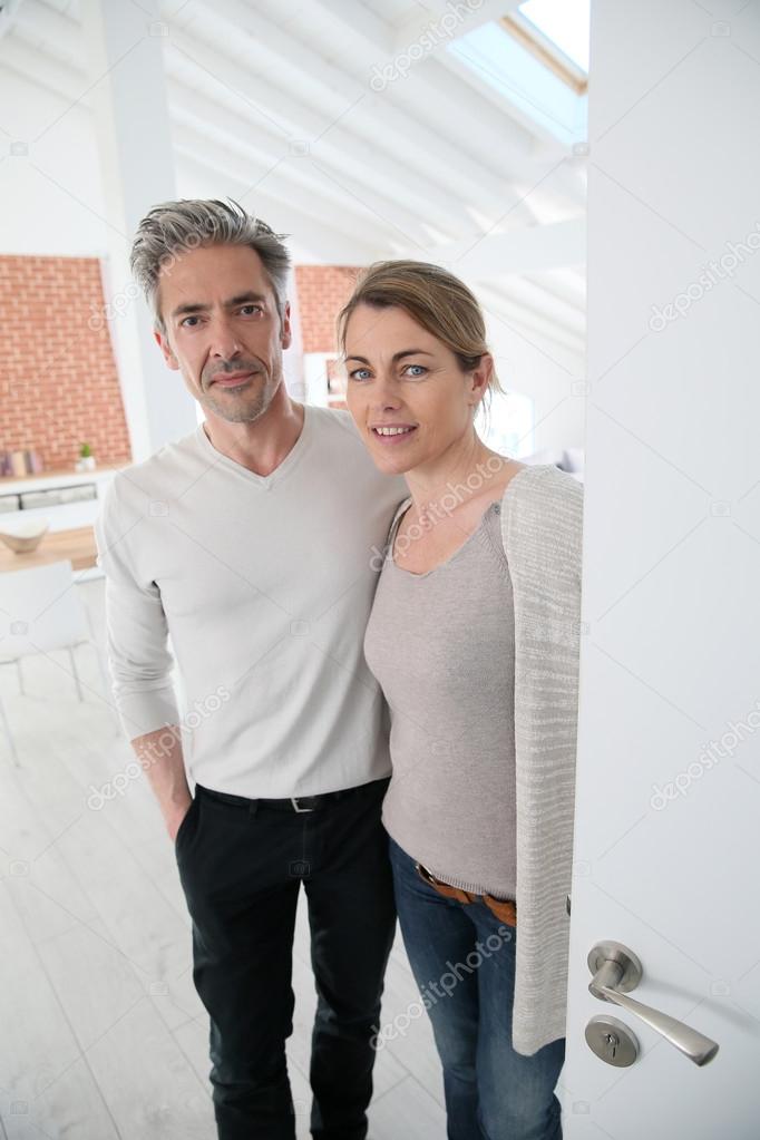 Couple opening door of home