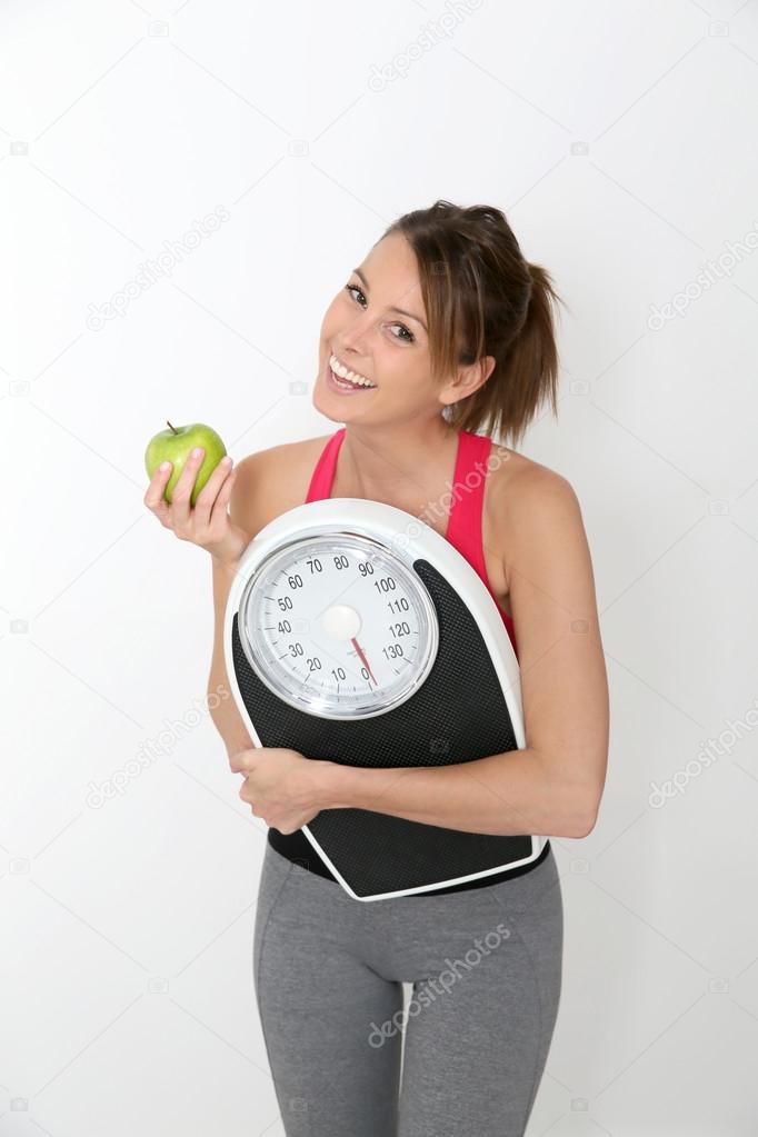 Girl holding scale and apple