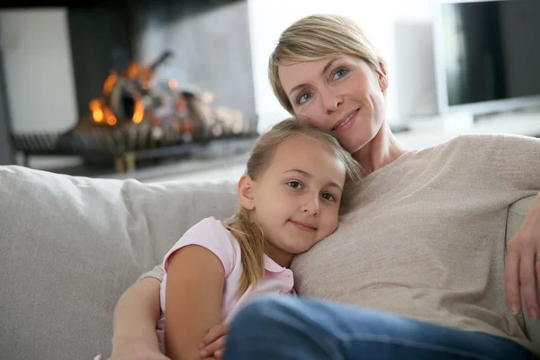 Mãe e filha relaxando por lareira — Fotografia de Stock