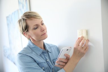 Woman programming indoor temperature clipart