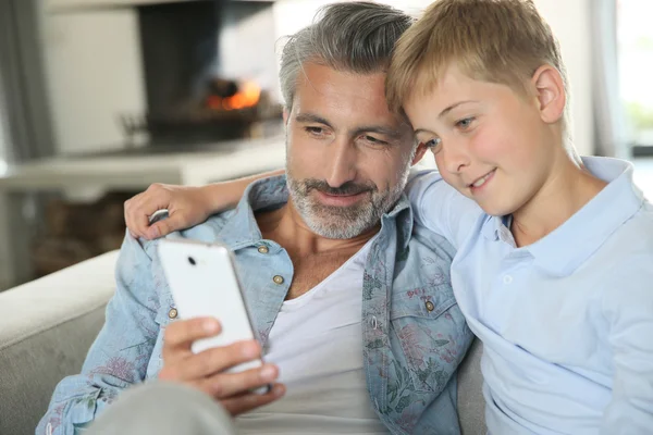 Papa und Sohn spielen mit Smartphone — Stockfoto