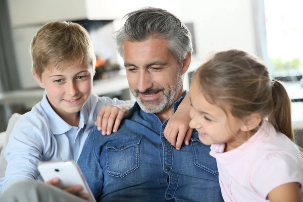 Man with kids playing with smartphone — Stock Photo, Image