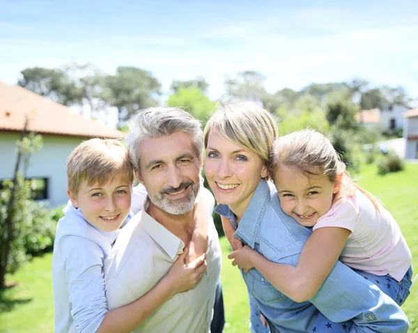 Parents giving piggyback ride to kids — Stock Photo, Image