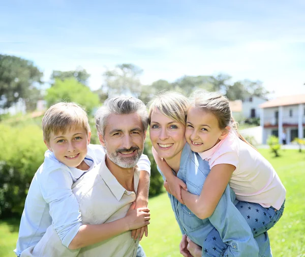 Parents giving piggyback ride to kids — Stock Photo, Image