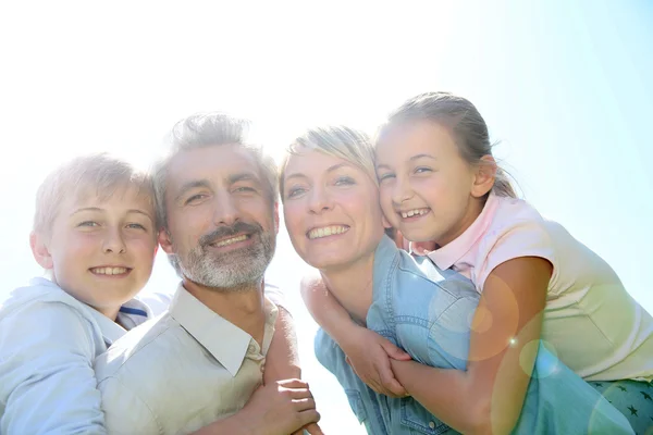 Parents giving piggyback ride to kids — Stock Photo, Image